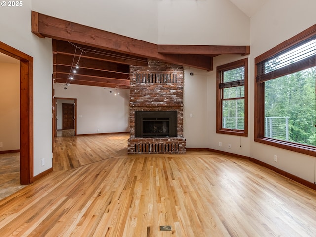 13200 NW Old Germantown Rd, Portland, OR 97035 - unfurnished living room with wood finished floors, a brick fireplace, healthy amount of natural light, and baseboards