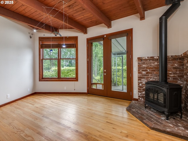 13200 NW Old Germantown Rd, Portland, OR 97035 - unfurnished living room featuring wood finished floors, a wood stove, wooden ceiling with exposed beams, and baseboards