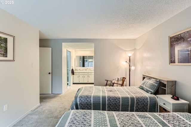 carpeted bedroom with sink, connected bathroom, and a textured ceiling