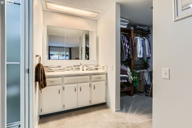 bathroom featuring vanity, decorative backsplash, and a textured ceiling