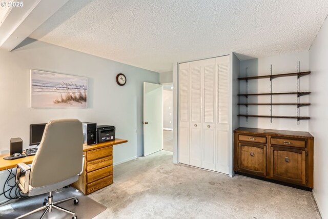 carpeted home office featuring a textured ceiling