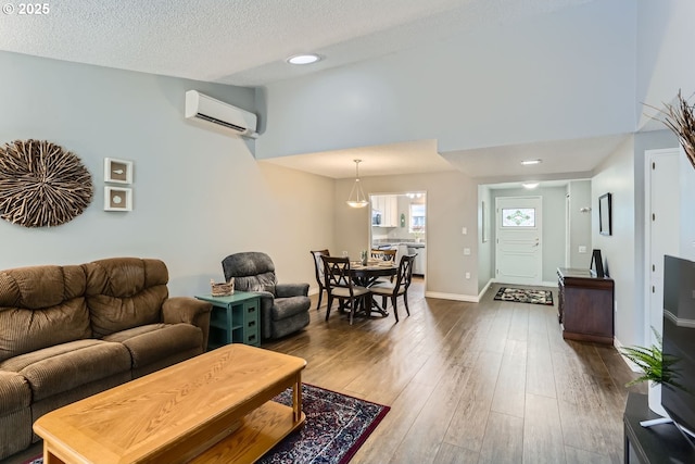 living room featuring high vaulted ceiling, dark wood-type flooring, a wall unit AC, and a textured ceiling