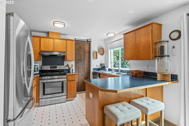 15205 NE 47th St, Vancouver, WA 98682 - kitchen featuring stainless steel appliances, brown cabinets, a peninsula, and under cabinet range hood