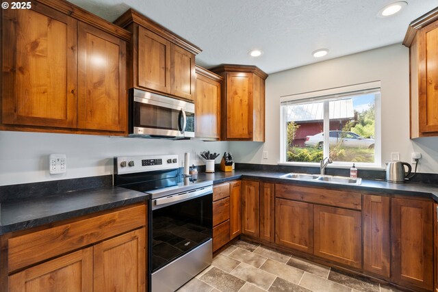 kitchen with a sink, brown cabinets, and stainless steel appliances