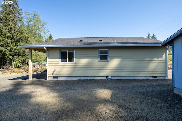 back of property with crawl space and a shingled roof