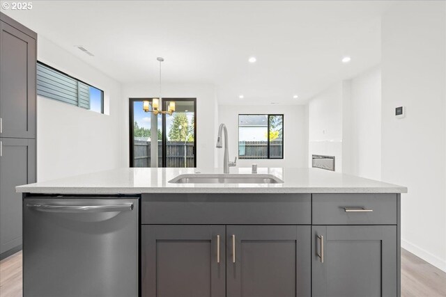 kitchen featuring appliances with stainless steel finishes, light countertops, light wood finished floors, a center island with sink, and recessed lighting