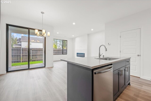 kitchen featuring appliances with stainless steel finishes, a sink, light countertops, light wood-type flooring, and recessed lighting