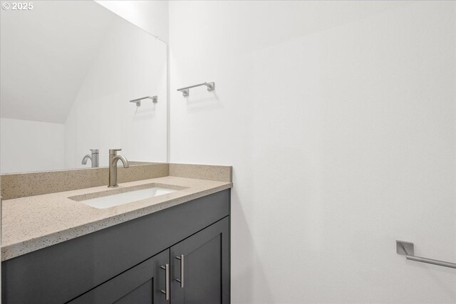 bathroom featuring lofted ceiling and vanity