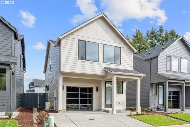 view of front of home with an attached garage, driveway, fence, and central AC