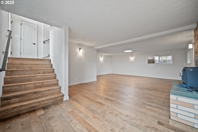 1908 50th St, Washougal, WA 98671 - unfurnished living room featuring light wood finished floors, stairs, and a textured ceiling
