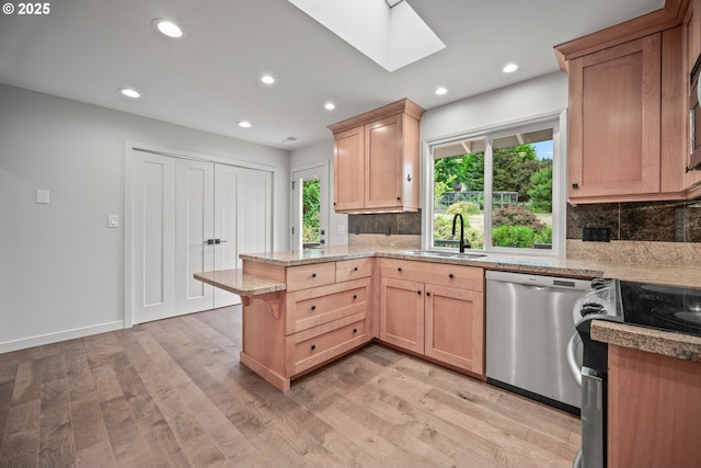1908 50th St, Washougal, WA 98671 - kitchen featuring stainless steel dishwasher, electric range oven, a peninsula, a skylight, and tasteful backsplash