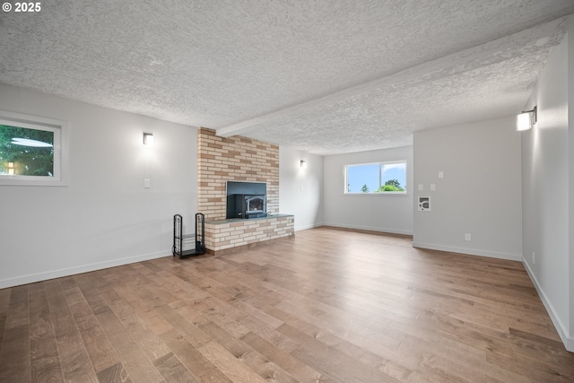 1908 50th St, Washougal, WA 98671 - unfurnished living room with wood finished floors, a textured ceiling, and a wood stove