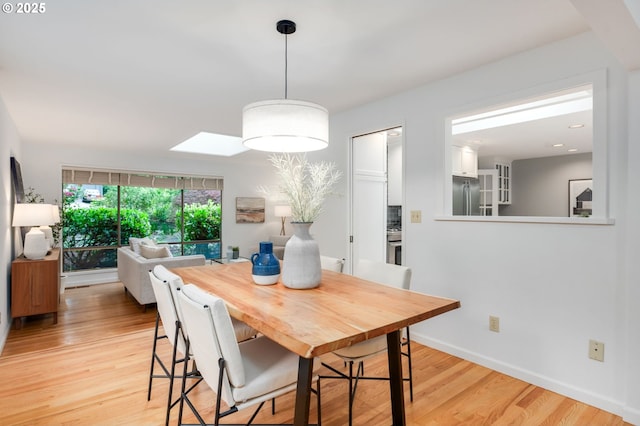 dining room featuring light wood-style flooring and baseboards