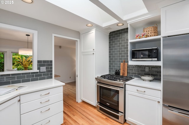 kitchen with stainless steel appliances, decorative backsplash, white cabinetry, light countertops, and recessed lighting
