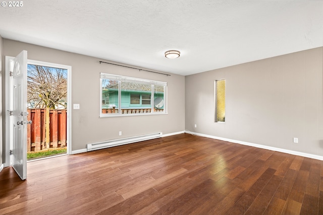 unfurnished room with a textured ceiling, wood finished floors, baseboards, and a baseboard radiator