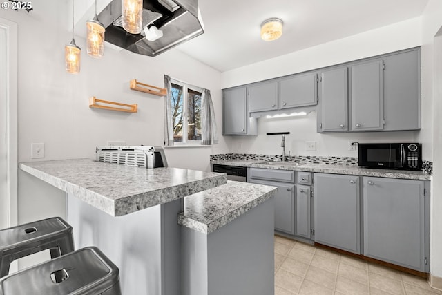 kitchen featuring black microwave, gray cabinets, a kitchen breakfast bar, a peninsula, and stainless steel dishwasher