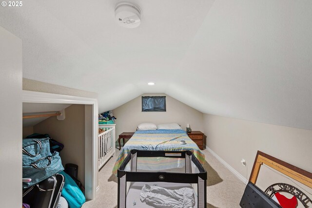 carpeted bedroom featuring lofted ceiling and baseboards