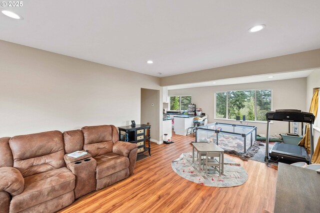 living area with light wood-type flooring, recessed lighting, and baseboards