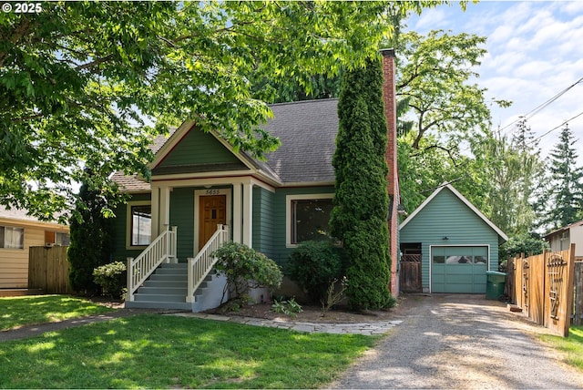 5655 SW Lombard Ave, Beaverton, OR 97005 - view of front of home with gravel driveway, a detached garage, an outbuilding, and a chimney