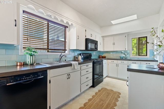 5655 SW Lombard Ave, Beaverton, OR 97005 - kitchen with black appliances, dark countertops, light flooring, white cabinets, and a skylight