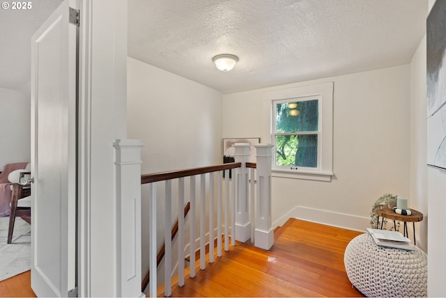 5655 SW Lombard Ave, Beaverton, OR 97005 - corridor with an upstairs landing, light wood-type flooring, and a textured ceiling