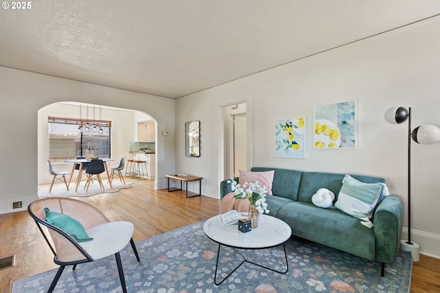 5655 SW Lombard Ave, Beaverton, OR 97005 - living area with arched walkways, wood finished floors, and a chandelier