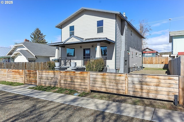 view of front of house with covered porch and a fenced front yard