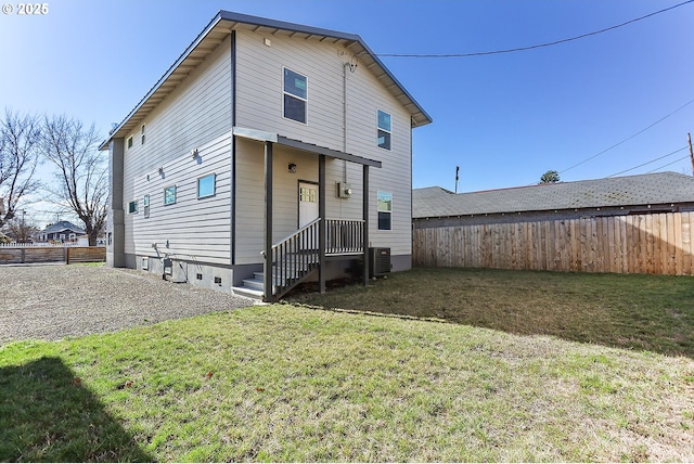 rear view of house featuring a yard, fence, and central air condition unit