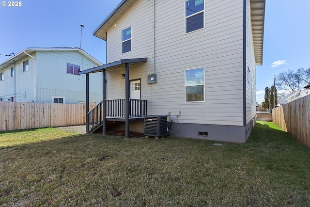 rear view of house with crawl space, central AC unit, a lawn, and a fenced backyard