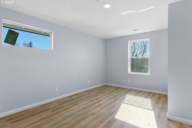 spare room featuring baseboards and wood finished floors