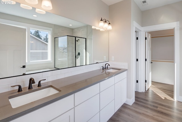414 Hedin Ter, Gaston, OR 97119 - full bathroom featuring a stall shower, wood finished floors, double vanity, baseboards, and backsplash