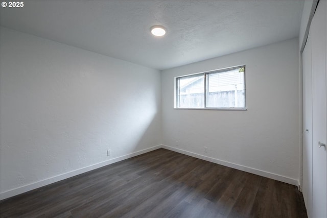 spare room with dark hardwood / wood-style flooring