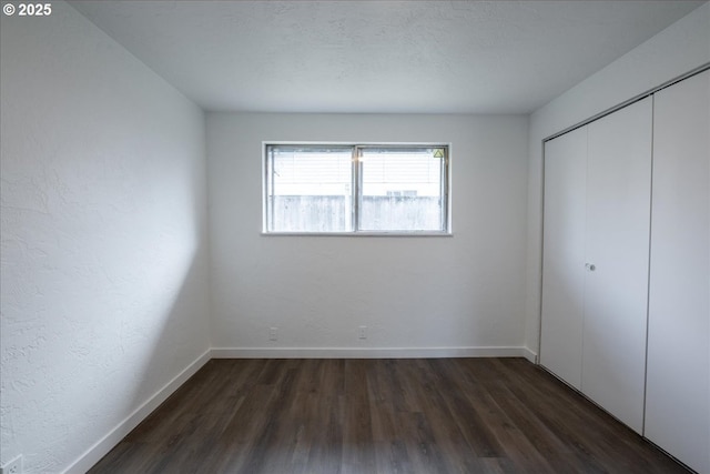 unfurnished bedroom featuring dark hardwood / wood-style floors and a closet