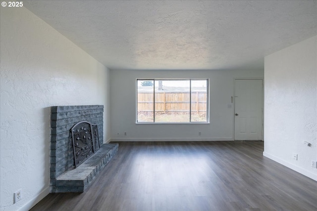 unfurnished living room with dark wood-type flooring and a textured ceiling