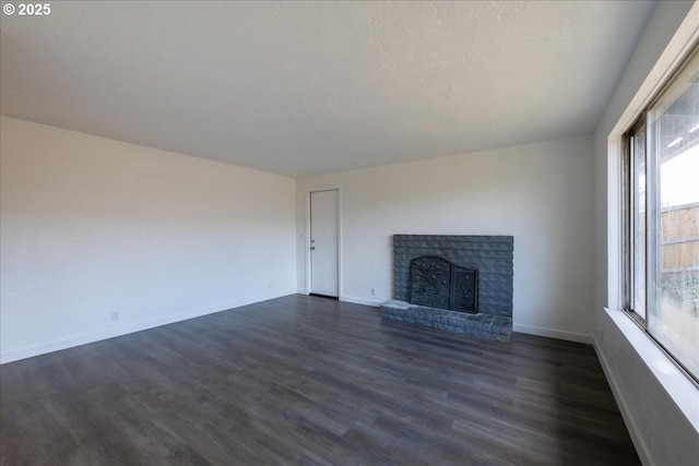 unfurnished living room featuring dark hardwood / wood-style flooring, a fireplace, and a textured ceiling