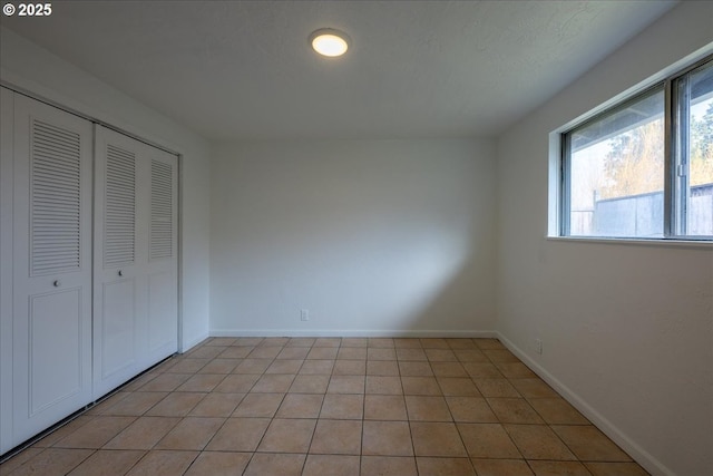 unfurnished bedroom featuring a closet and light tile patterned floors