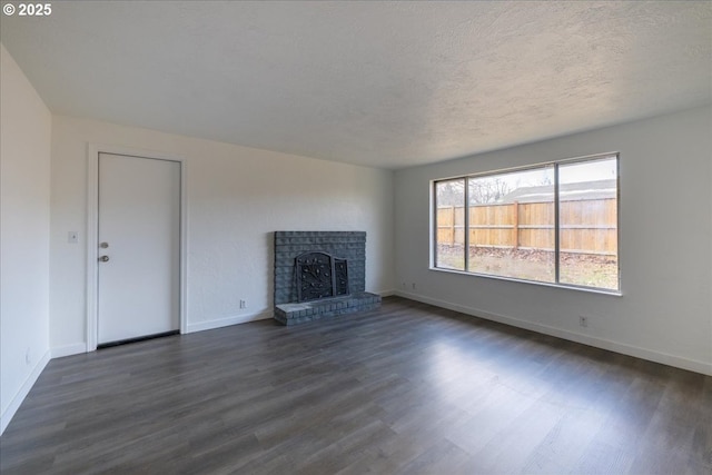 unfurnished living room with a fireplace, a textured ceiling, and dark hardwood / wood-style flooring