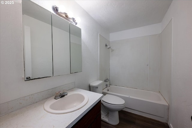 full bathroom featuring vanity, bathtub / shower combination, hardwood / wood-style flooring, toilet, and a textured ceiling