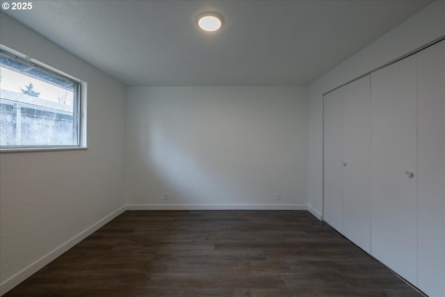 unfurnished bedroom featuring dark hardwood / wood-style floors and a closet