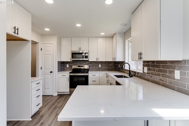 2977 Dry Creek Rd, Eugene, OR 97404 - kitchen featuring a sink, electric range oven, stainless steel microwave, light wood-style flooring, and white cabinetry