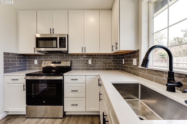 2977 Dry Creek Rd, Eugene, OR 97404 - kitchen with stainless steel appliances, a sink, light countertops, and wood finished floors