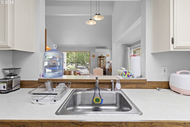 10137 SW Trapper Ter, Beaverton, OR 97008 - kitchen featuring white cabinetry, a wall mounted air conditioner, pendant lighting, vaulted ceiling, and light countertops
