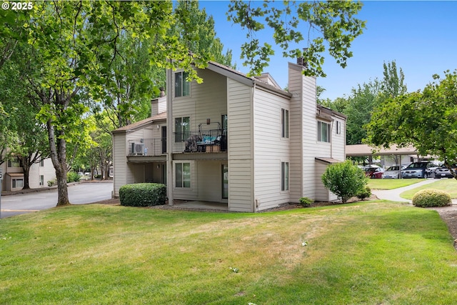 10137 SW Trapper Ter, Beaverton, OR 97008 - view of home's exterior with a chimney, a yard, a balcony, and cooling unit