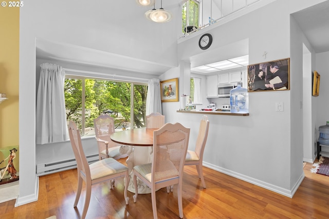 10137 SW Trapper Ter, Beaverton, OR 97008 - dining room featuring healthy amount of natural light, a baseboard heating unit, and light wood-style flooring