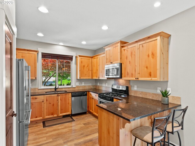 5703 SE 10th St, Gresham, OR 97080 - kitchen featuring stainless steel appliances, a peninsula, light brown cabinetry, light wood-type flooring, and recessed lighting