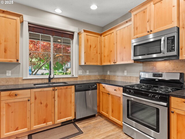 5703 SE 10th St, Gresham, OR 97080 - kitchen with stainless steel appliances, light brown cabinetry, recessed lighting, light wood-type flooring, and decorative backsplash