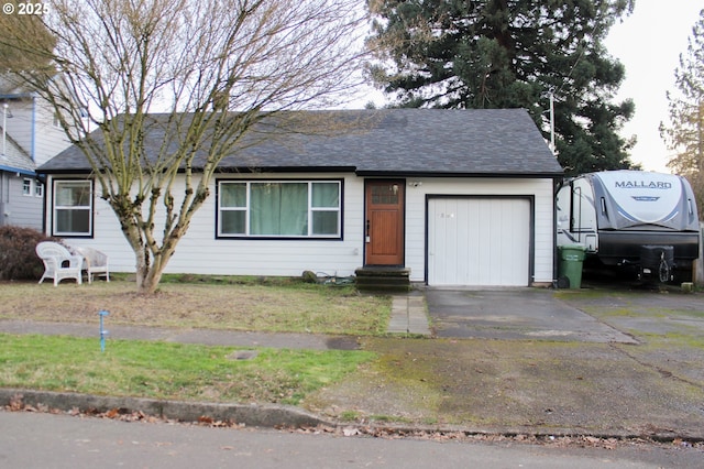 ranch-style house with a garage, roof with shingles, and driveway