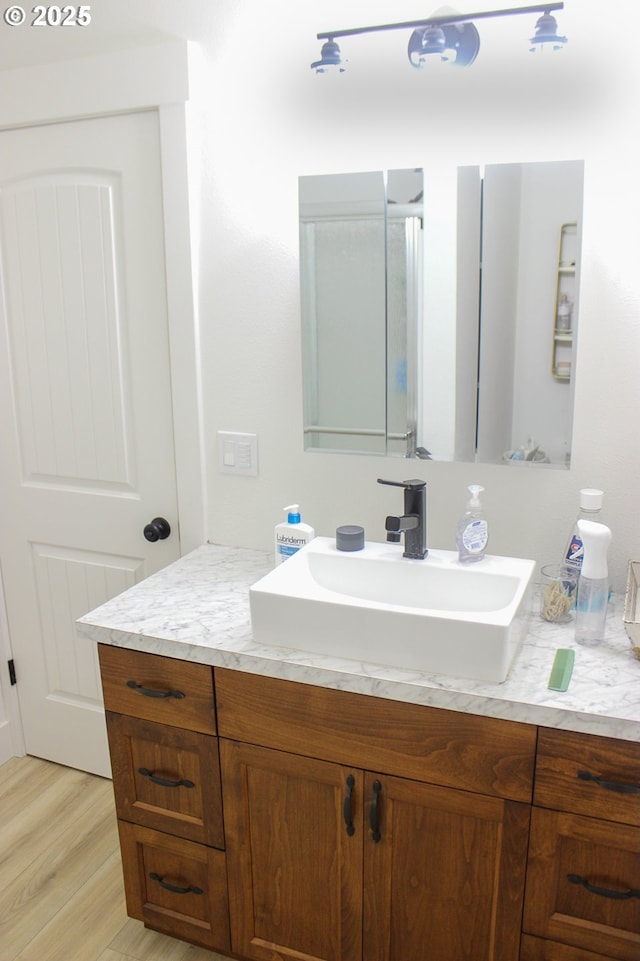 bathroom with wood finished floors and vanity