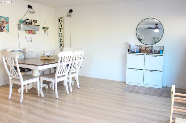 dining space featuring baseboards and light wood-style floors