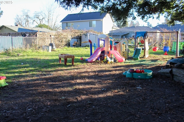 community play area with a lawn and fence